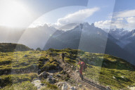 Hikers on the way to Lacs De Cheserys from Argentiere with Les Drus and Aiguille Verte on the background, Haute Savoie, France