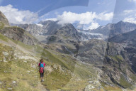 Hiker on path Sentiero Glaciologico with Fellaria Glacier in the background, Malenco Valley, Valtellina, Lombardy, Italy