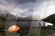 Hikers and tent on the shore of Lacs De Cheserys at night with Mont Blanc massif on background, Chamonix, Haute Savoie, France