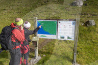 Hikers looking to maps, Gasadalur, Vagar island, Faroe Islands, Denmark