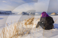 Woman on Haukland Beach covered with snow, Leknes, Vestvagoy, Lofoten Islands, Norway
