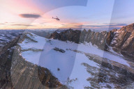 Aerial view of helicopter in flight on Scerscen Superiore at sunset, Valmalenco, Valtellina, Lombardy, Italy