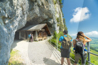 Hikers on walkway to the ancient caves, Wildkirchli, Ebenalp, Appenzell Innerrhoden, Switzerland