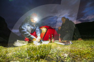 Hikers having meal out of the tent at lake Riffelsee, Zermatt, canton of Valais, Switzerland