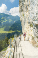Mother and children on walkway to Aescher-Wildkirchli Gasthaus, Ebenalp, Appenzell Innerrhoden, Switzerland