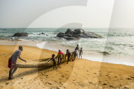 Locals pushing a canoe in the ocean east of Buchanan, Liberia