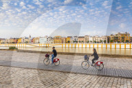 People cycling by the river Rio Guadalquivir, with Triana district in the background, Seville, Andalusia, Spain, Europe