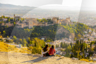 Two women looking at view of Alhambra and Sierra Nevada mountains, Granada, Andalucia, Spain, Europe
