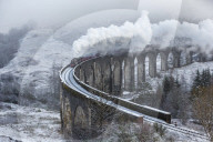 A wintery scene of the Glenfinnan Railway Viaduct with steam locomotive, Highlands, Scotland, United Kingdom, Europe.