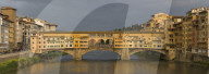 A panorama of the Ponte Vecchio bridge spanning the Arno river in Florence.