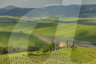 A Tuscan villa perched on a hill in the early evening light of the Val d'Orcia