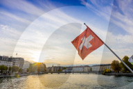Swiss Flag at sunset, River Rhone, Geneva, Switzerland, Europe.