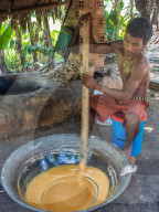 Man making palm sugar over a fire, village home near Siem Reap, Cambodia, Southeast Asia