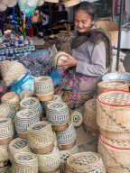 Woman selling baskets for sticky rice in central outdoor market, Luang Prabang, Laos, Southeast Asia