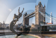 Juxtaposition of David Wynne's Girl With A Dolphin Statue near Tower Bridge in London, Victorian engineering on the river Thames