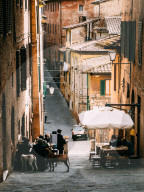 Small alleyway with quaint restaurant in Siena, Tuscany, Italy
