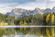 Lodge, forest and Karwendel Alps reflect themselves on the waters of Gerold Lake. KrÃ¼n, Upper Bavaria, Bavaria, Germany.
