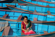 Nepalese woman and boats of Phewa Lake, Pokhara, Nepal.
