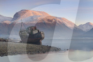 Wreck of old fishing boat & view towards the snow capped peak of Ben Nevis from Loch Linnhe Lochaber Scottish Highlands Scotland
