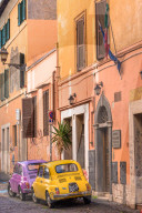Two vintage Fiat 500s with Roma number plates parked in colourful backstreet of Trastevere, Italy, Lazio. Italy.