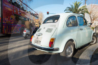 Rome traffic with classic Fiat 500 car, scooter and tourist bus, seen on city street, Lazio, Italy.