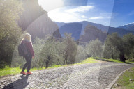 A young tourist walks on the Via Crucis. Arco di Trento, Trento province, Trentino Alto Adige, Italy, Europe.