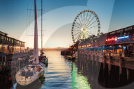 Sunset over mountains with Seattle Great Wheel on Pier 57 in the foreground. Seattle, Washington State, USA, North America