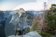 A couple takes a break at Glacier Point to look at Half Dome in Yosemite National Park.