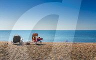 People relaxing on deckchairs on the beach, Brighton, East Sussex, England, United Kingdom, Europe