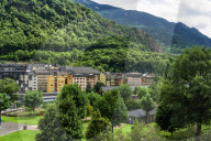Andorra la Vella, Andorra day view of local buildings by a green hill on the capital of the Principality of Andorra.