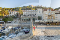The main square (Trg Svetog Stjepana) of Hvar Town with view to the Spanish Fortress in the background at first sunlight