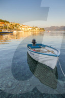 Small boat anchoring outside the old town at first sunlight, Korcula Town, Croatia