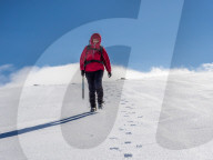 Female Winter Walker descending a fresh snowy slope in the Cairngorm National Park