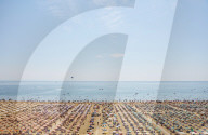 Sun umbrellas cover the beach, elevated view