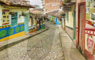 A typically colourful street with buildings covered in traditional local tiles in the picturesque town of Guatape in Colombia.