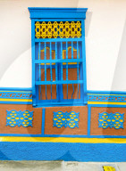 The facade of a colourful building covered in traditional local tiles, in the picturesque town of Guatape in Colombia.