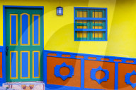The facade of a colourful building covered in traditional local tiles, in the picturesque town of Guatape in Colombia.