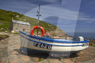Fishing boat and cottage above the cobbled slipway at Penberth Cove, Cornwall, England, U.K.