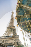 Eifel tower with a classic carousel in the foreground early in the morning
