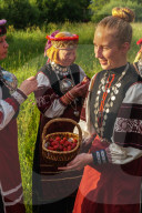 Seto girl offers wild strawberries to friends, Feast Day, Uusvada, Setomaa, SE Estonia (Model Release of girl signed by Mother)