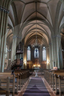 Nave of St Gertrude Old Church, worshipper in pew, (the oldest Sayer organ in Latvia built 1906), Riga, Latvia