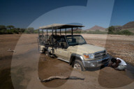 Guide tries to jack up safari vehicle stuck in the sand of Hoarusib Riverbed, Puros, north of Sesfontein, Nambia (Model Release)