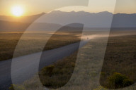 Grand Teton park, car on dusty road at sunset