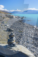 Inukshuk, pile of small stones, lake shore of glacial lake Pukaki, Mount Cook National park South Island, New Zealand, NZ
