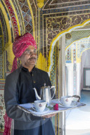 India, Rajasthan, Jaipur, Samode Palace, Waiter carrying Tea Tray in ornate passageway - Model and Property released