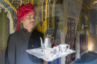 India, Rajasthan, Jaipur, Samode Palace, Waiter carrying Tea Tray in ornate passageway - Model and Property released