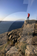 A hiker looks out to sea from cliffs at Fair Head, Northern Ireland