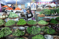 Two cheerful young men running a fresh vegetable stall in the main city vegetable market, Bhuj, Gujarat