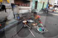 Woman making the day's chapatis on a wood fire in the street outside near the Jama Mosque in old Ahmedabad