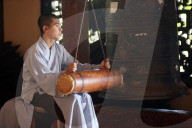 Linh An buddhist pagoda. Young monk ringing bell in monastery. Dalat. Vietnam.